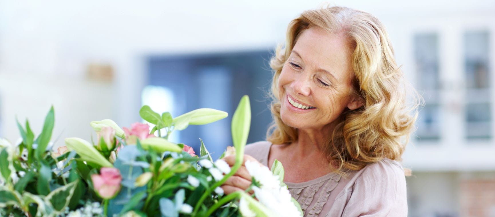 woman rearranging flowers in her home