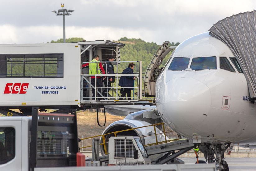 An ambulift assisting a woman on the plane