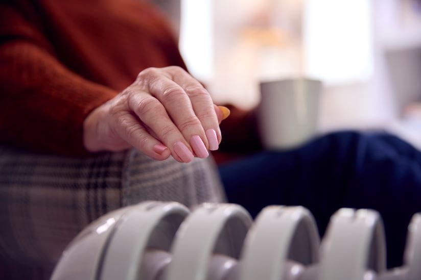 womans hand going to touch the radiator to check the heat