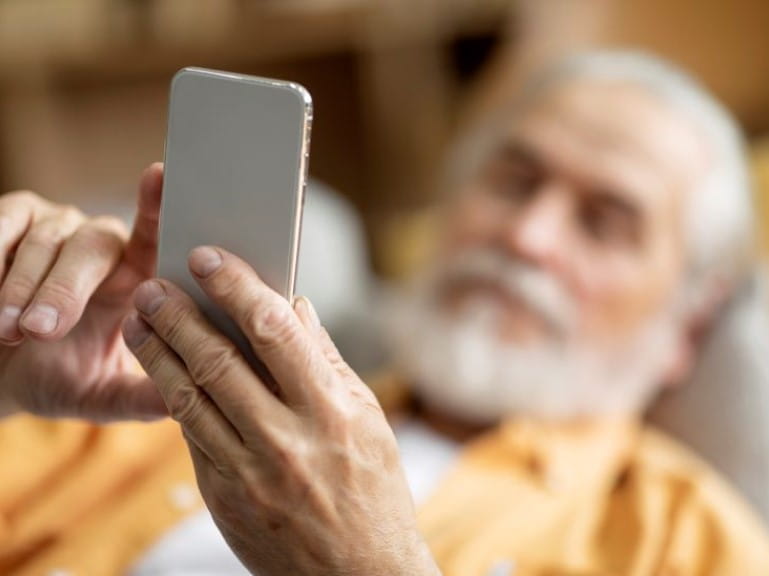 man lying on the sofa sorting his phone out for travel