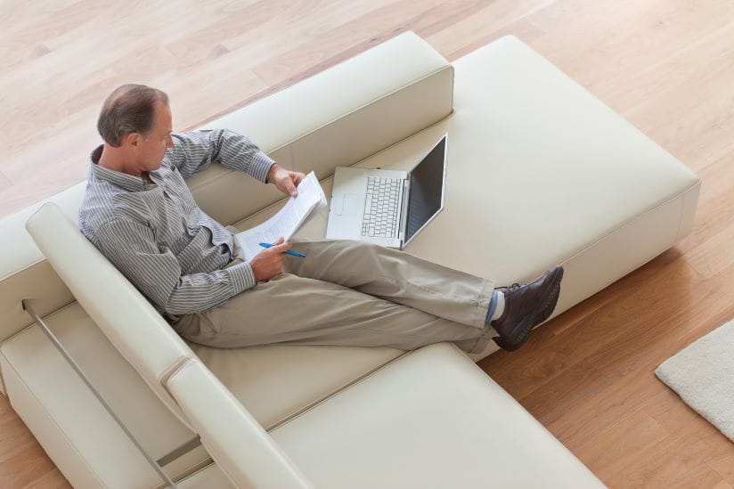 Man sitting on the sofa with his laptop sorting his finances