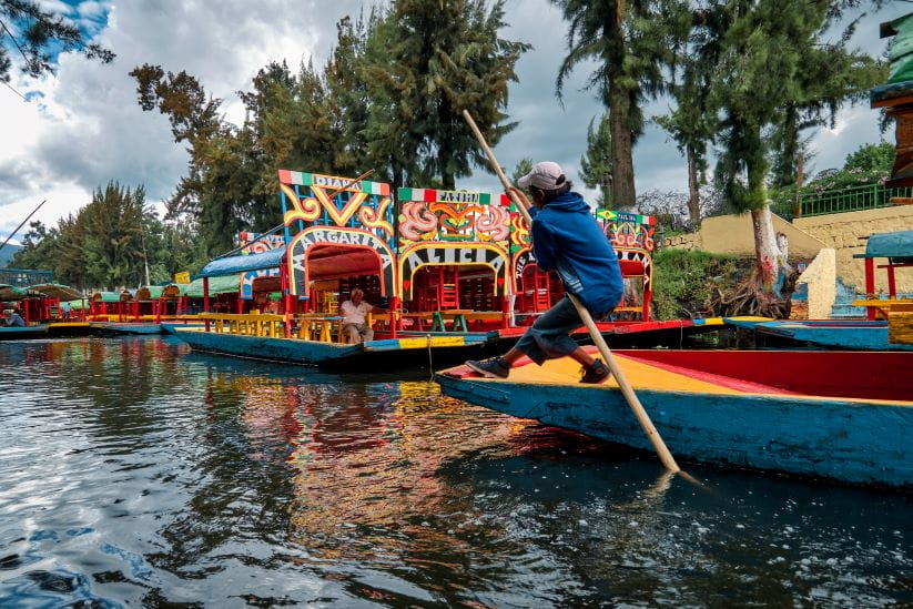 Young trajinero rows the trajinera into Xochimilco channel