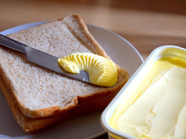margarine being spread on bread
