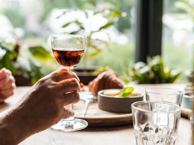 Someone holding a glass of sherry in a restaurant setting