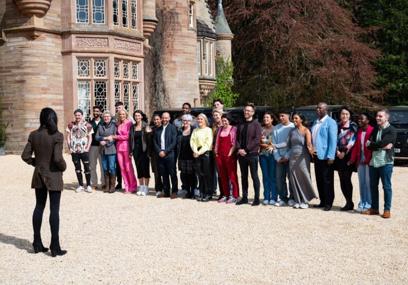 The contestants of The Traitors standing outside the castle with Claudia Winkleman