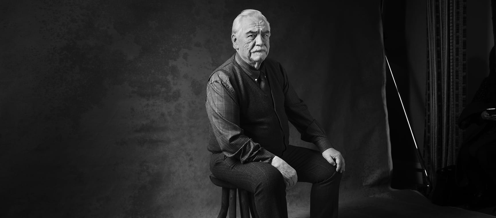 Brian Cox sitting in black and white