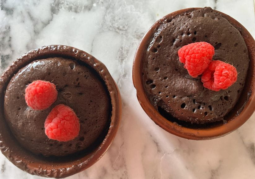two chocolate puddings with a raspberry on top