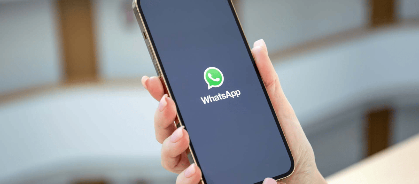 Someone holding up a phone with the whatsapp app on it