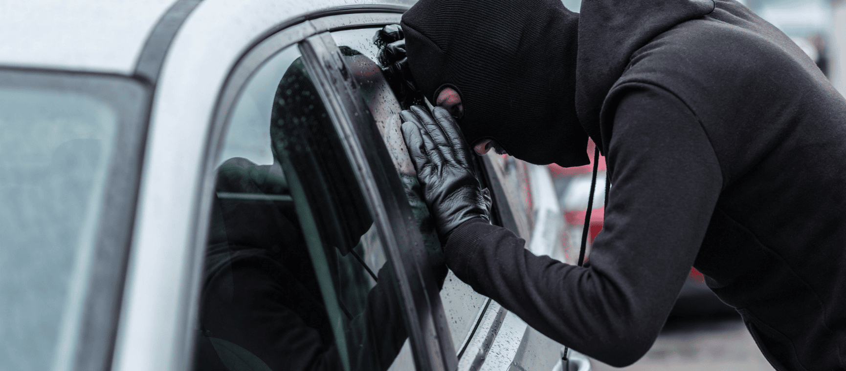 a thief looking through a car window