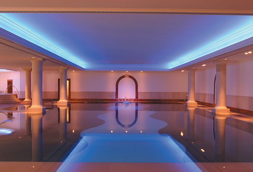 Luxurious undoor spa pool with soft lighting and grand pillars