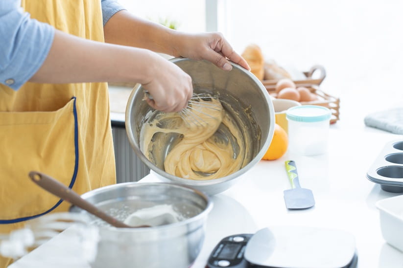 close up on hand of female mixing cake batter