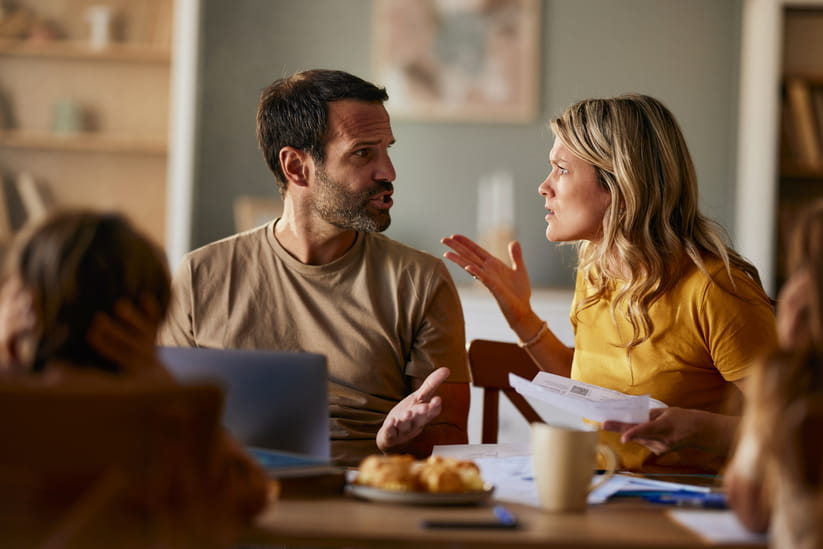 A woman talks angrily to a man while they stand in a kitchen
