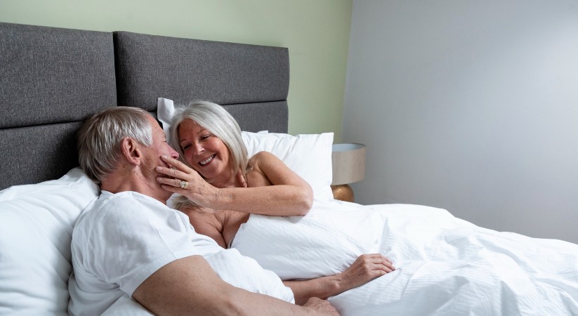 Older couple in bed looking at each other