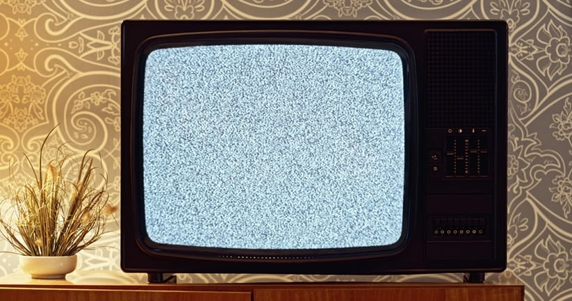 Close-up of snow on old television screen in living room.