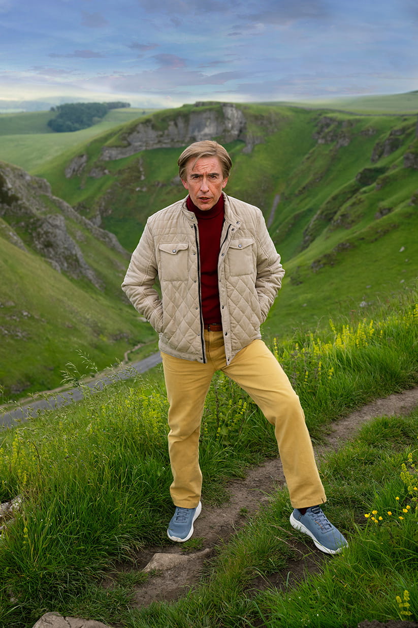 Alan Partridge standing on a hill