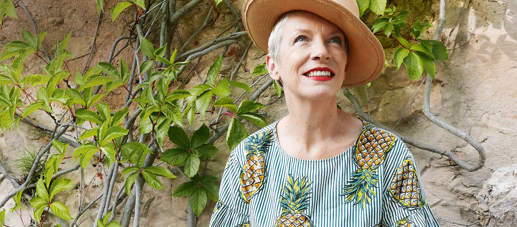 Annie Lennox wearing a hat and a flowery shirt