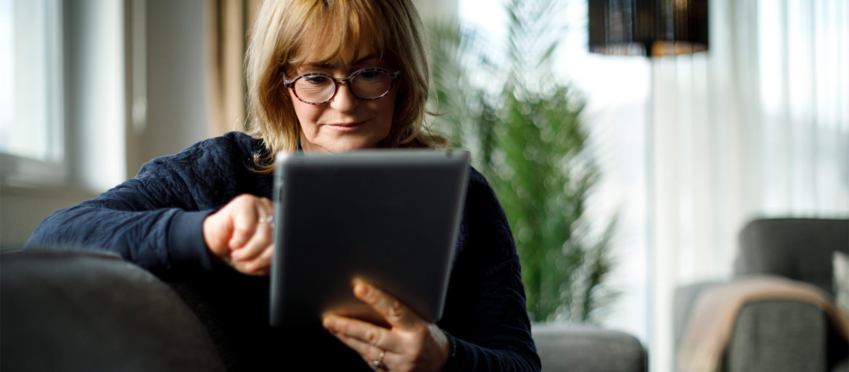 A woman scrolling on her digital tablet device