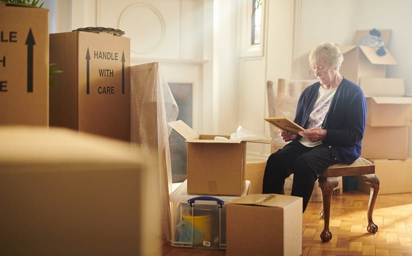Senior woman surrounded by packing boxes