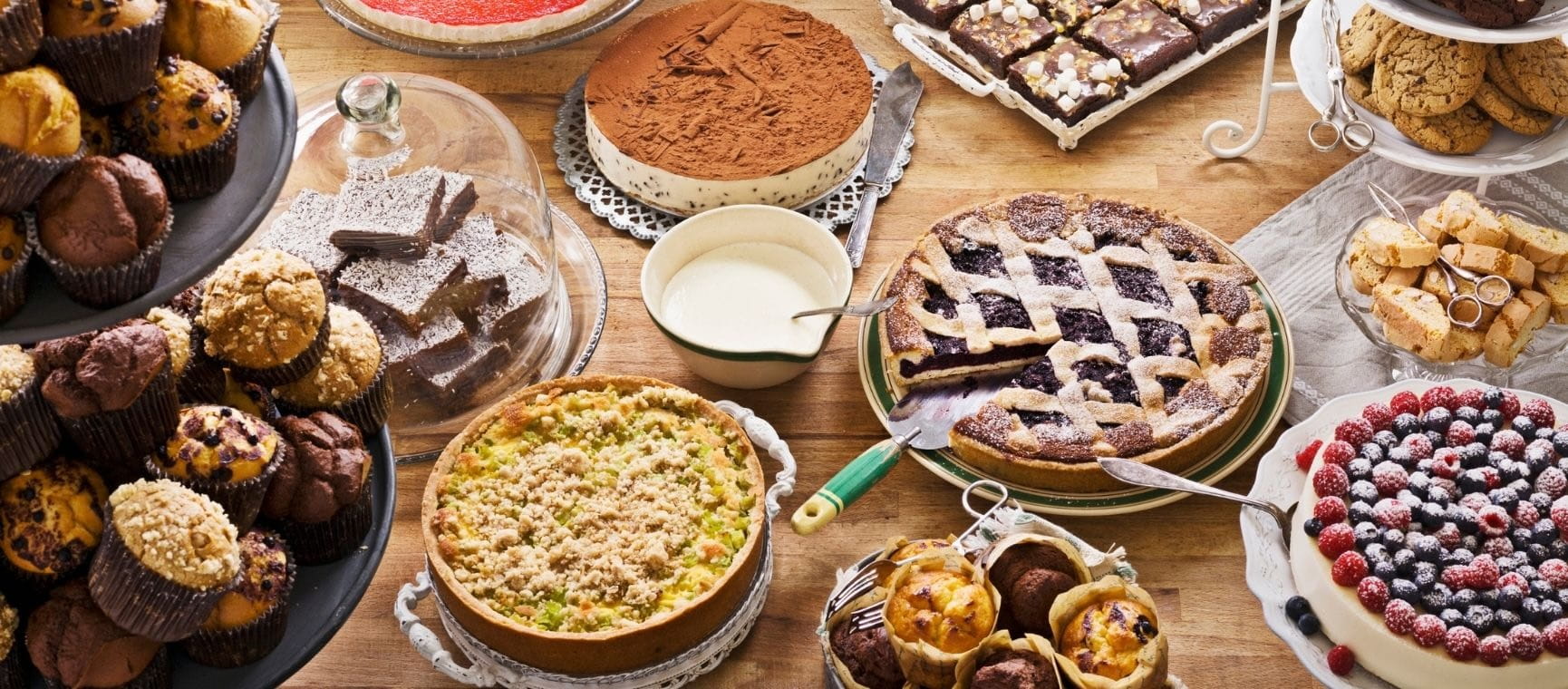 A variety of traditional puddings and cakes set out on a table