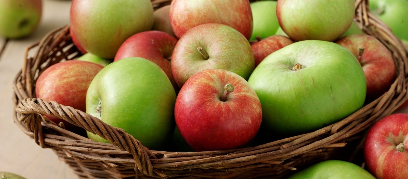 a wicker basket filled with apples
