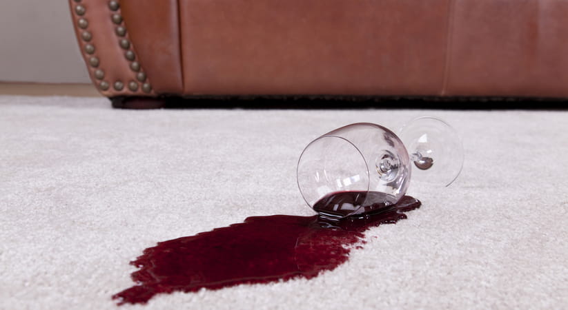 Knocked over glass with red wine stain on carpet