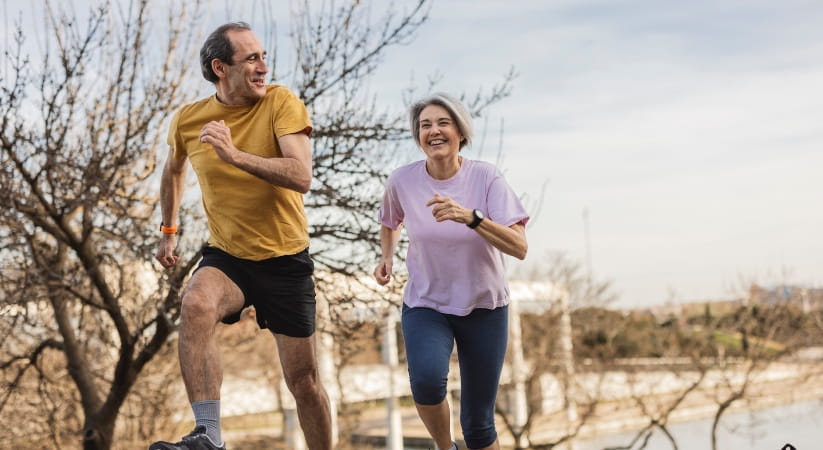 Older couple running in the countryside on a winter day