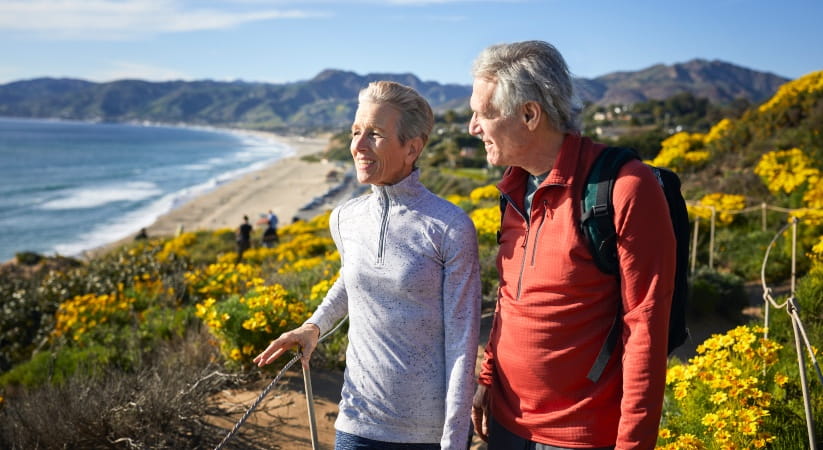 Older couple walking on a clifftop on a sunny day