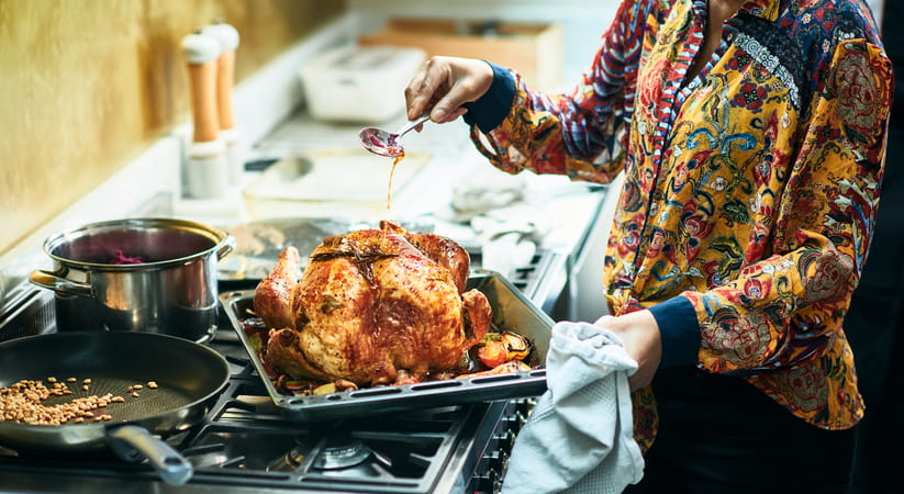 Woman roasting a turkey in a kitchen