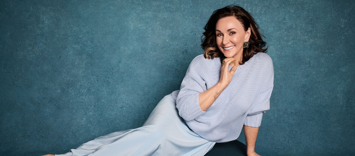 Shirley Ballas facing the camera in a semi-reclined pose