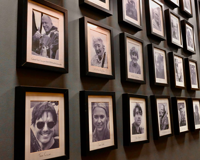 A wall of portraits of notable people who have flown in a Spitfires.com spitfire
