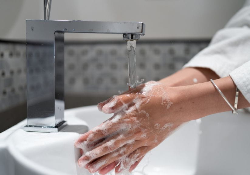 a woman washing her hands over a sink
