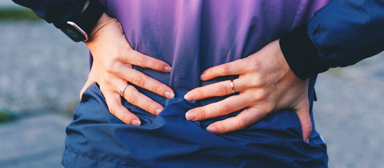 Close up of woman holding her lower back
