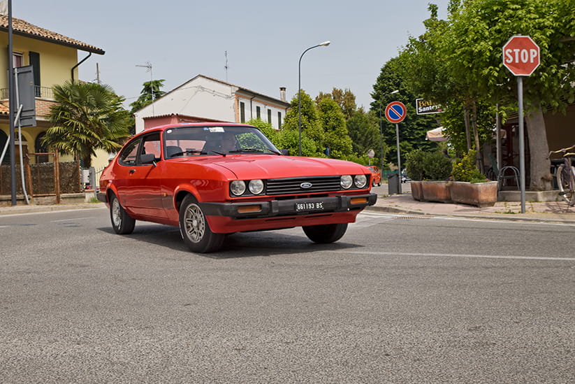 A red Ford Capri driving in Italy