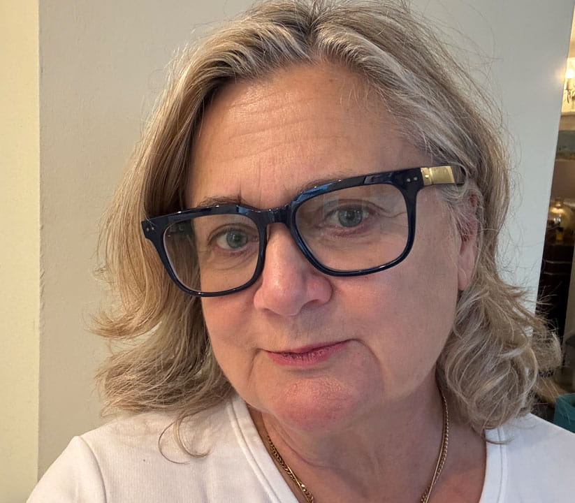 Head and shoulders of Jo Waters wearing a pair of black rimmed hearing specs