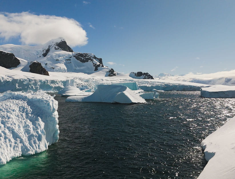 Icebergs with the sun shining from an almost cloudless sky in Antarctica