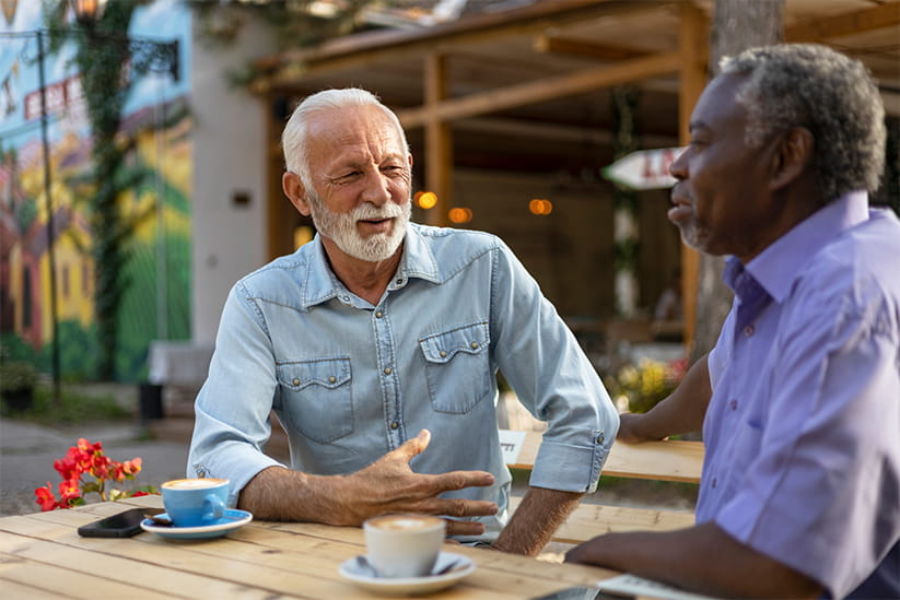 Two older male friends meeting for a coffee
