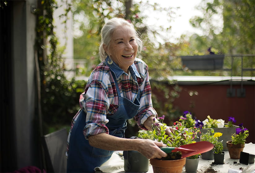 An older woman with a trowel doing some gardening