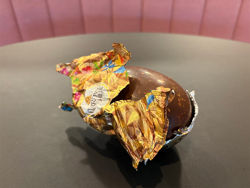 A Ferrero Rocher easter egg with half of its foil covering removed