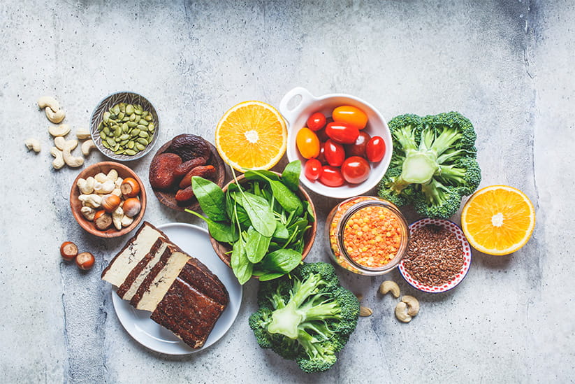 Oatmeal, lentils, tofu, broccoli, dried apricots and nuts arranged on a table