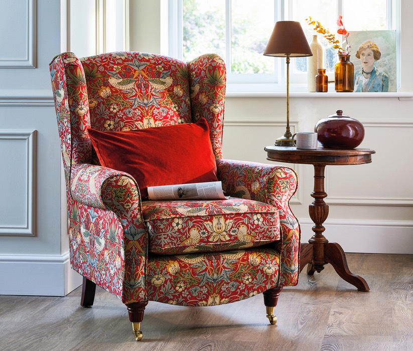 An HSL Glenmore armchair in a room with a wooden floor and a small table to its left