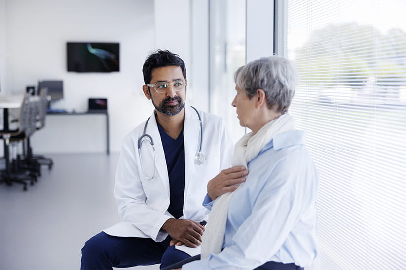 Doctor and patient in conversation in hospital hallway 