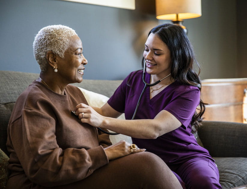 Nurse checking senior woman's vital signs in her home