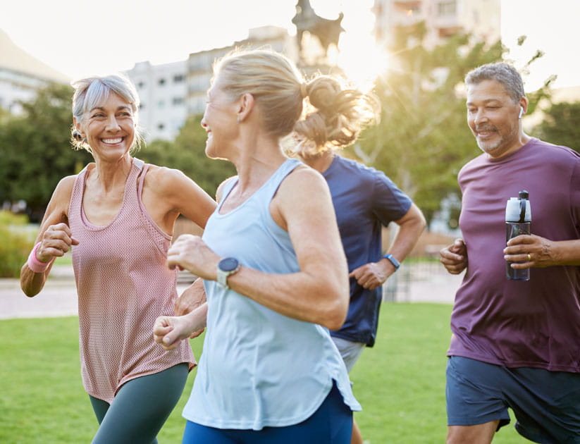 Group of senior friends running in the morning sunshine, enjoying fitness routine