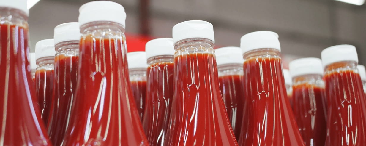 The tops of unbranded tomato ketchup bottles