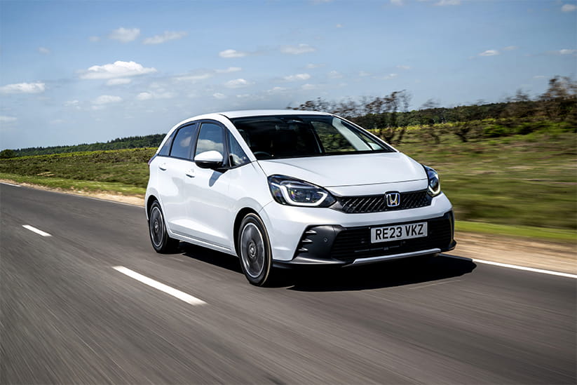 A white modern Honda Jazz driving along a road
