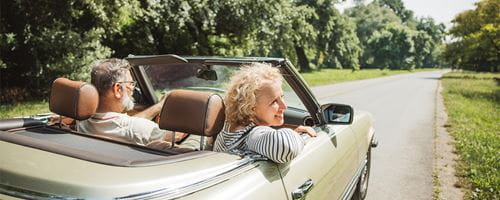 Happy senior couple enjoying in life while driving convertible car
