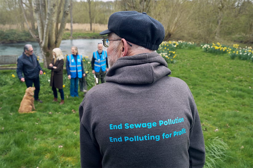 Geoff Tombs wearing a hoodie that reads "End sewage pollution End polluting for profit"