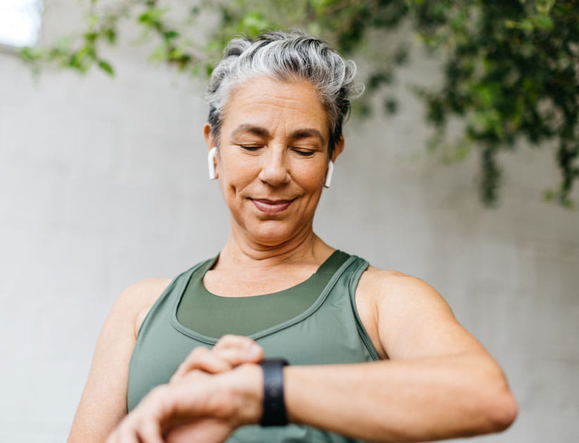 Mature woman using smart watch technology to check her stats