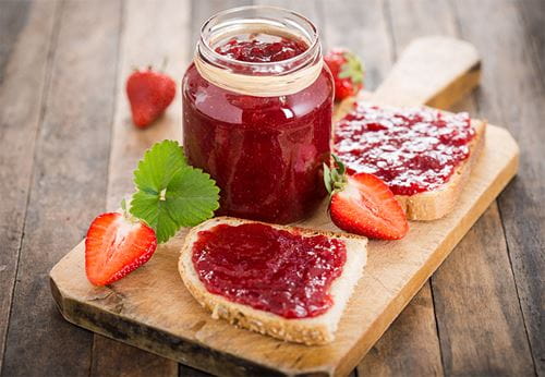 Strawberry jam on bread with fresh strawberries