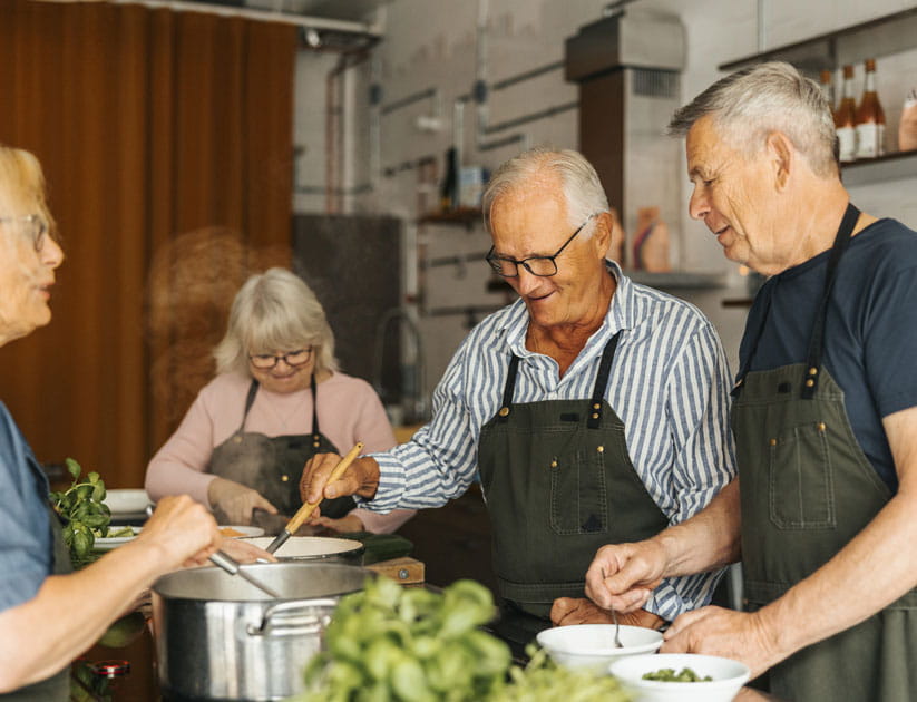 Senior men preparing food in cooking class at commercial kitchen